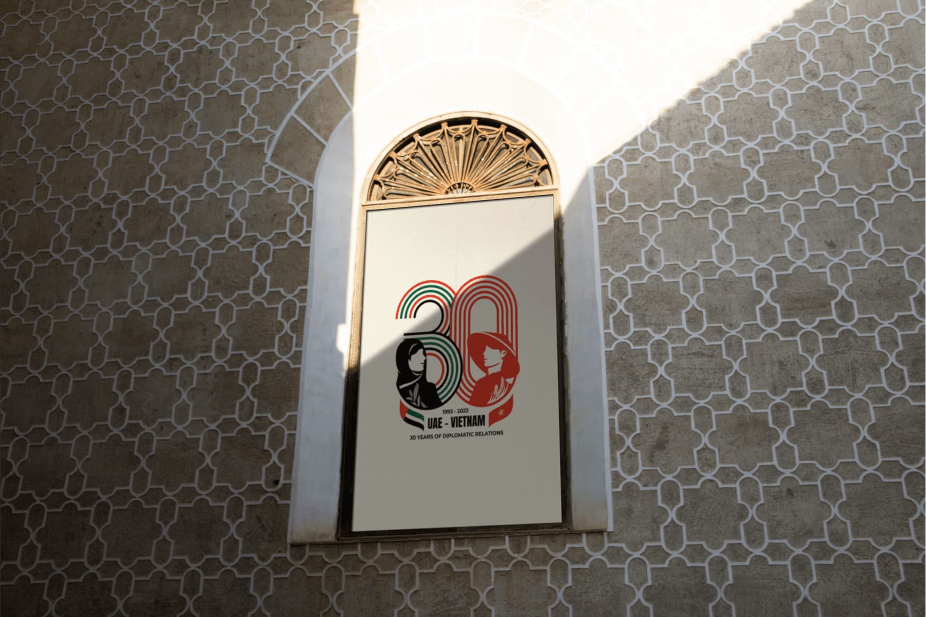 Arched doorway with colorful mural, framed by gray geometric patterned tiles in bright sunlight