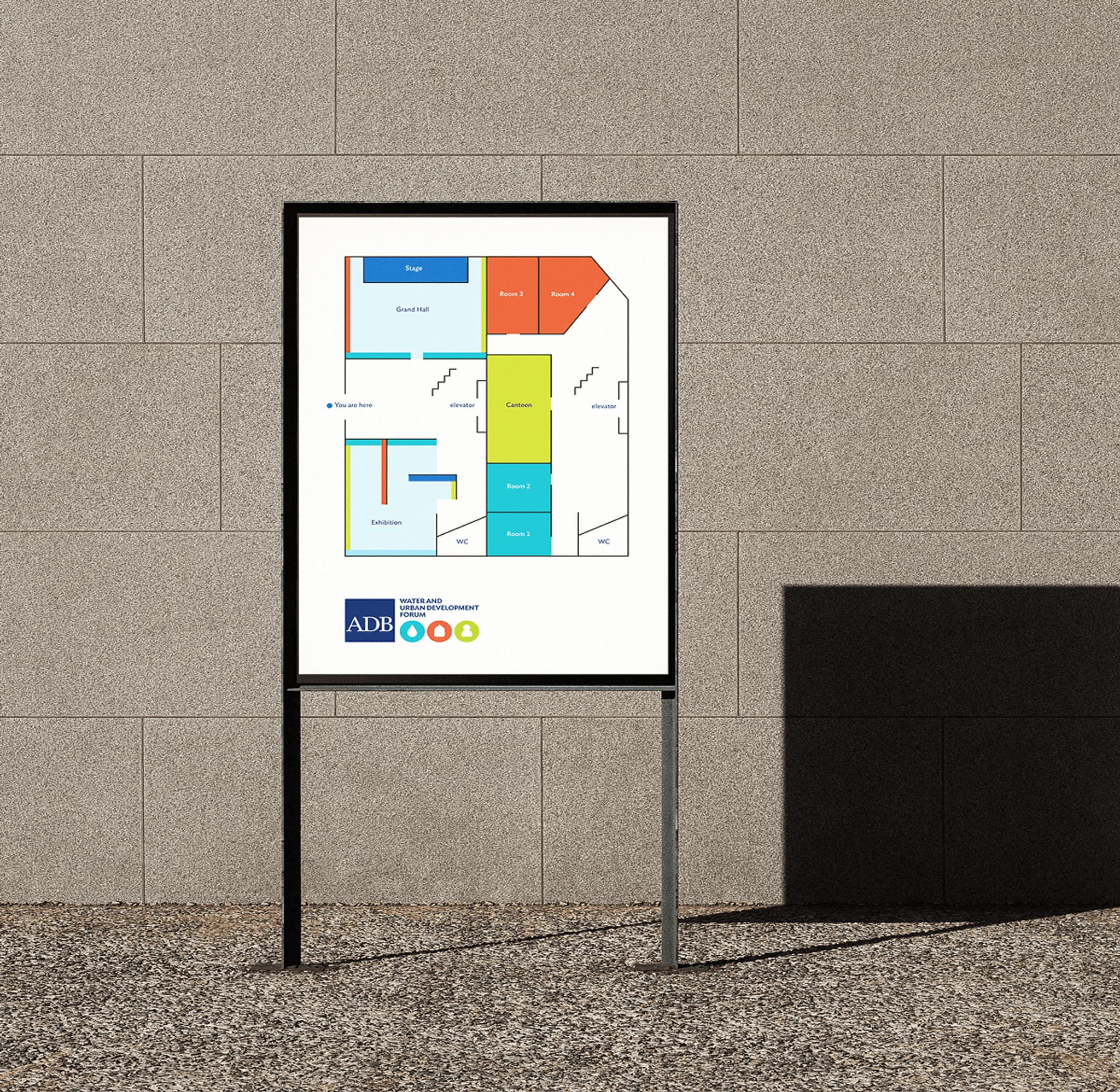 AWUF venue map signage featuring the forum’s new branding system, displayed on a metal stand against a textured wall.