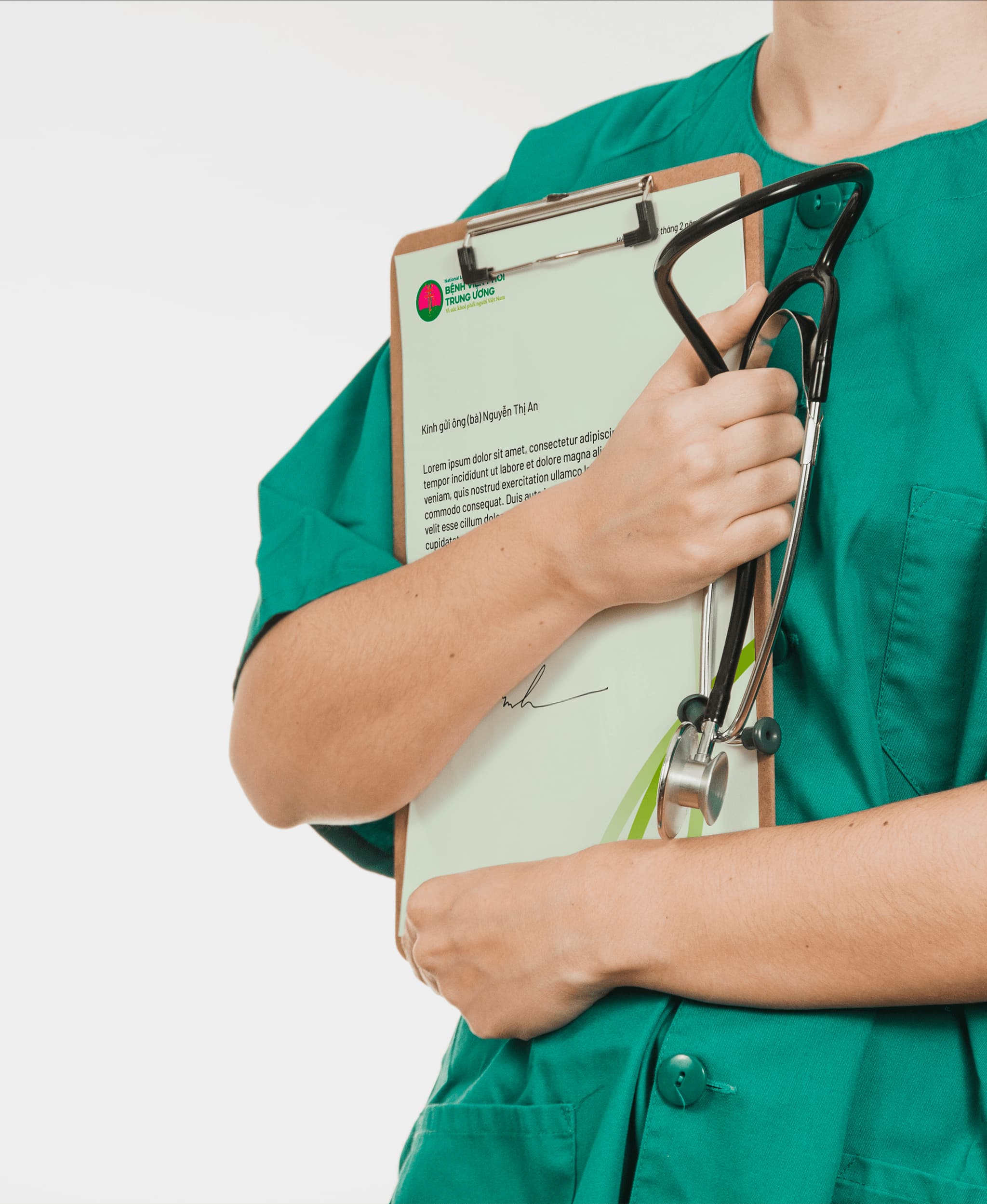Healthcare professional in green scrubs holding a clipboard and stethoscope, indicating a medical context.