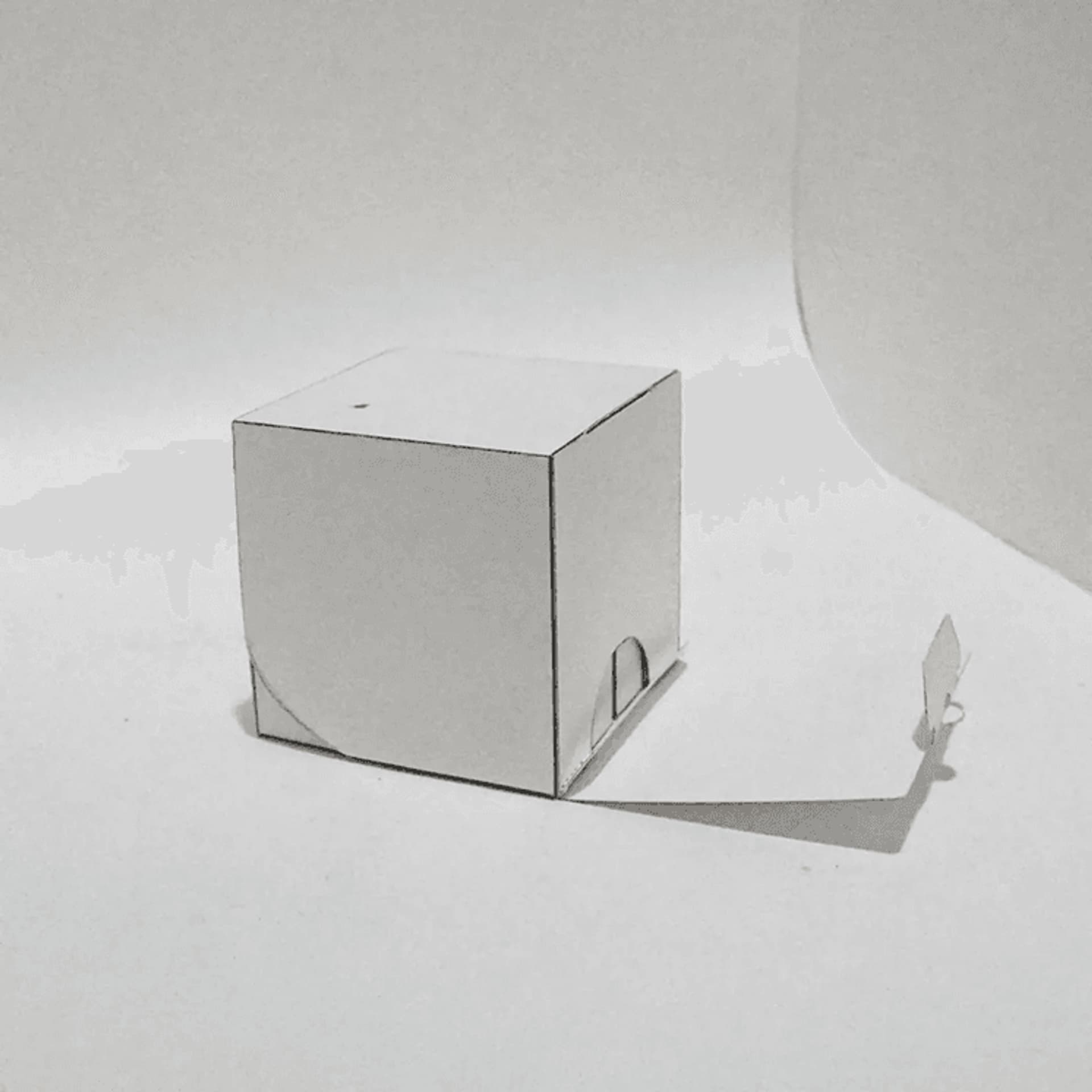 White cardboard box with a simple design, casting a soft shadow on a light background. Ideal for packaging or minimalist decor.