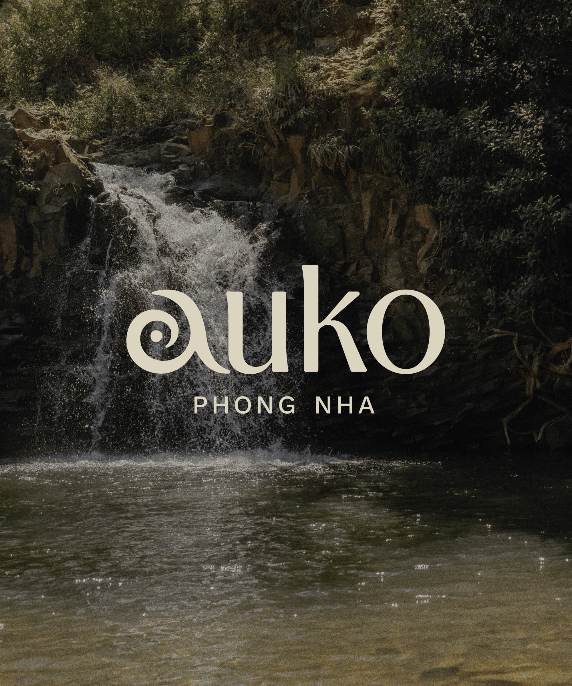 Auko Phong Nha logo over a lush jungle waterfall and natural swimming pool