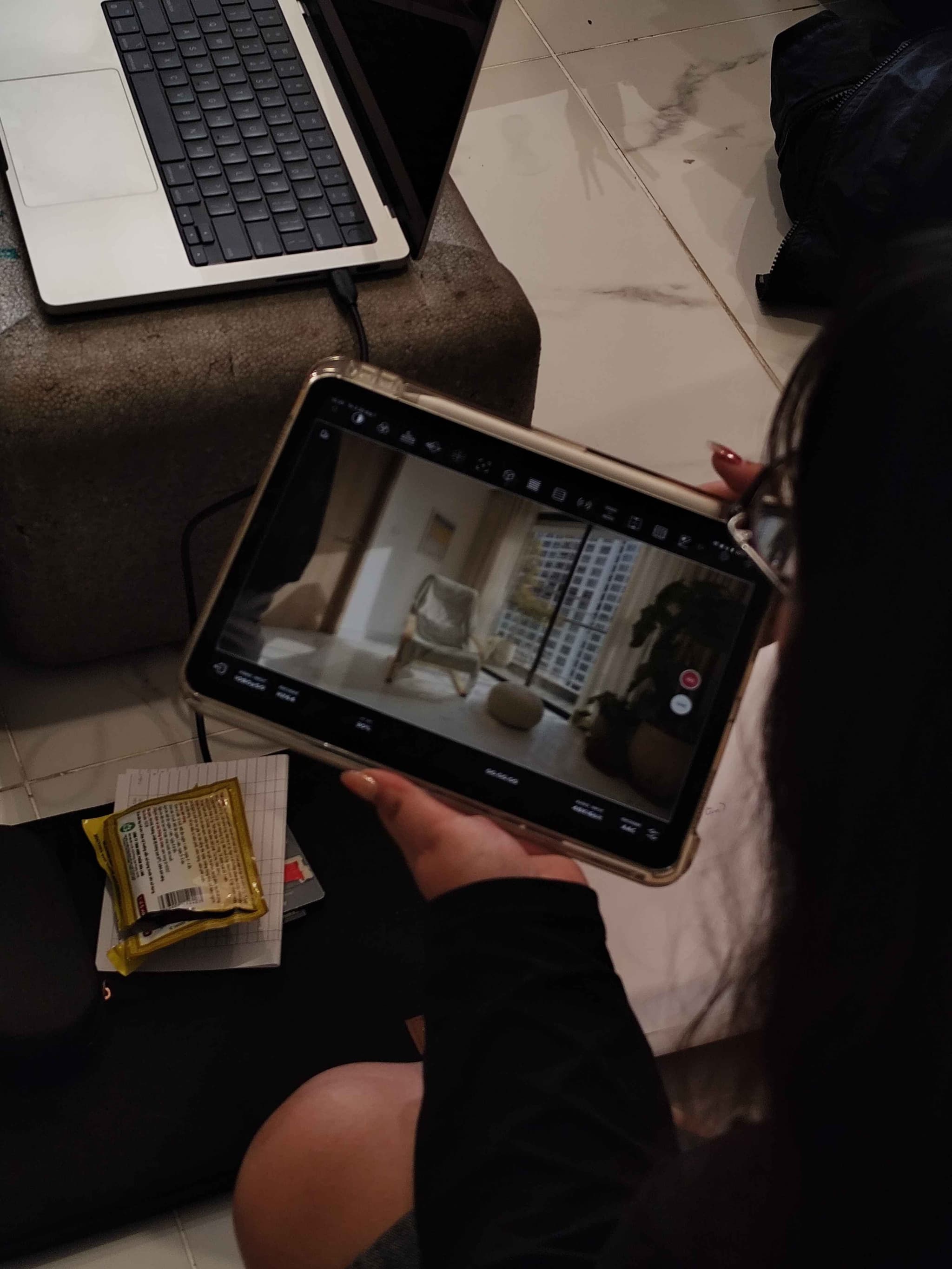 Person using a tablet with a map and handoff controls on a desk with laptop and workspace items