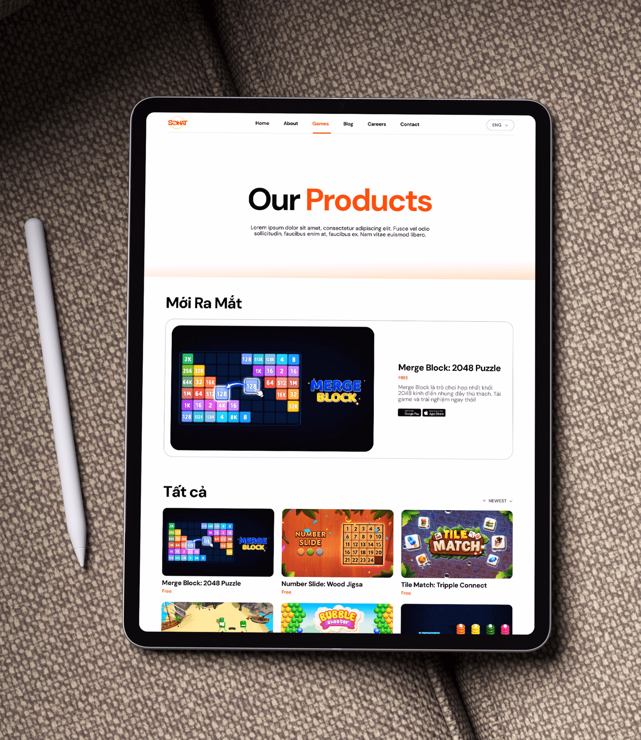 Tablet displaying a webpage titled "Our Products" featuring various puzzle game thumbnails and a stylus on a textured surface.