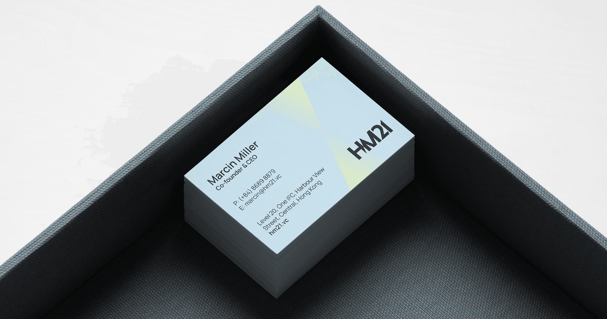 Business card mockup with a light blue design, featuring the name "March Miller" and contact information, placed in a black tray.